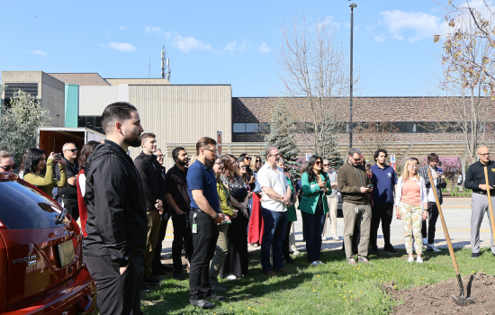 Students and staff gather to watch the tree planting ceremony