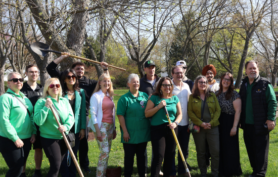 A group poses with shovels