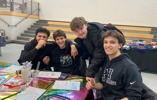 4 students smile and unwind at the colouring station