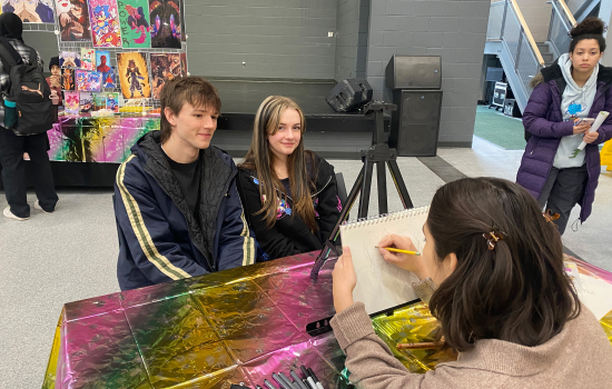 The caricature artist draws two students