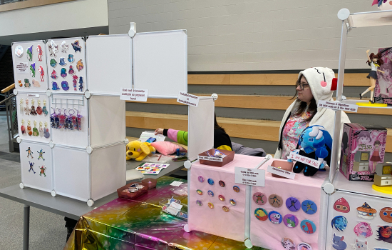Vendor art table featuring buttons stickers and keychains