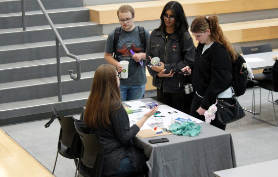 students speak to a vendor in the slc