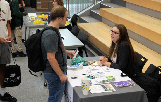 a student speaks to a vendor in the slc
