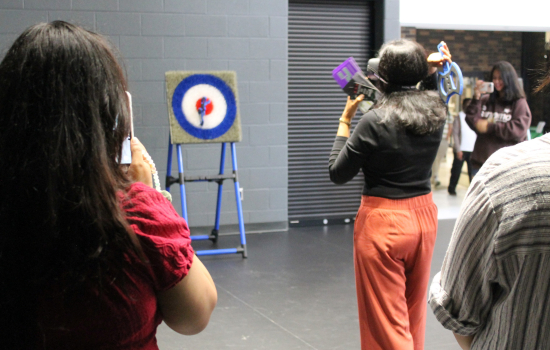 students try axe throwing with impairment goggles