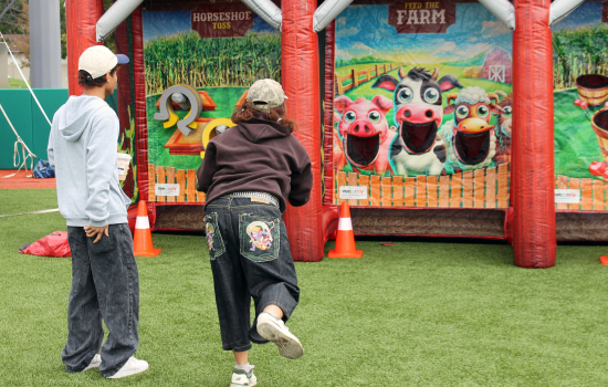 2 students playing an inflatable game