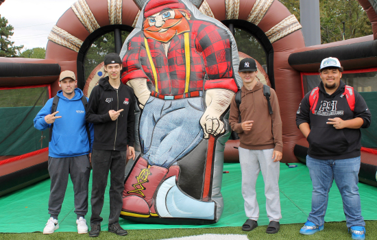 4 students pose with an inflatable lumberjack
