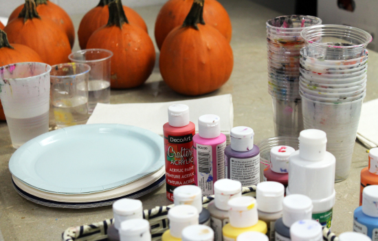 A close up of the paint supplies and pumpkins