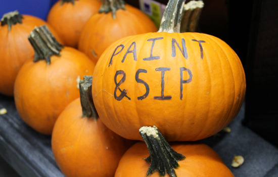 A close up of a pumpkin painted with "Paint & Sip"