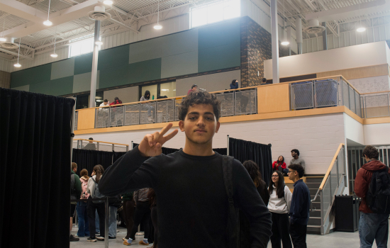 A student poses for a photo in the SLC while waiting their turn with a psychic
