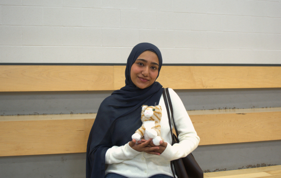 A student sits in the SLC with her new stuffy, an orange cat