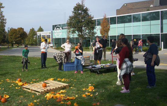 Students gather around the pumpkin smashing area by the St. Clair pond