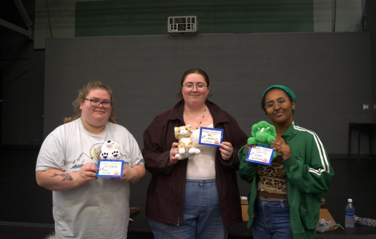 Three students show off their new besties complete with adoption certificates