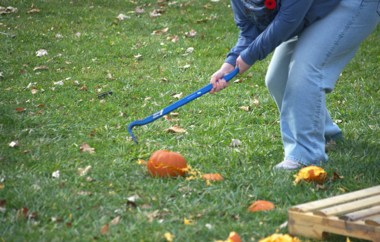 a closeup of a pumpkin mid-smash with a crowbar