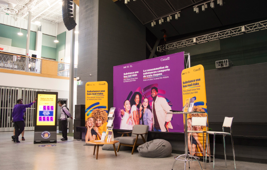 A clean, welcoming setup with large print backdrops, cozy bean bags and a digital screen