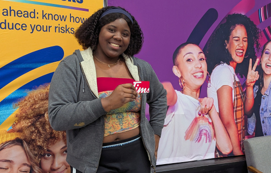 A student poses with their prize of a Tim's gift card